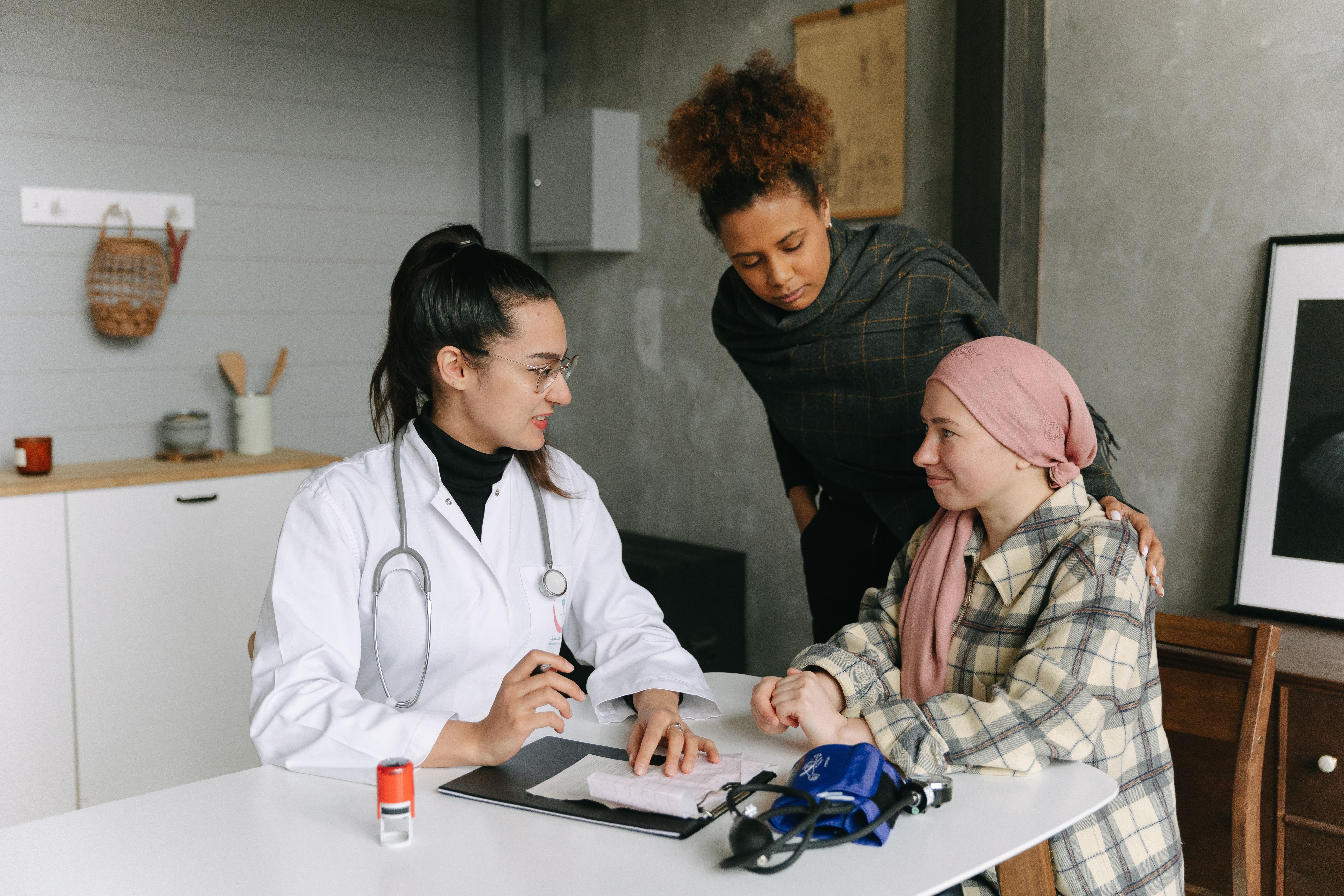 Geriatrician coordinating care with a caregiver and patient